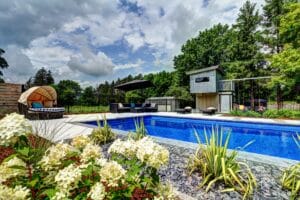 Luxurious backyard pool with patio and lounge area.