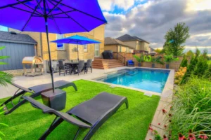 Backyard patio with pool and lounge chairs.