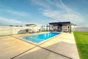 Modern backyard pool with patio and grass